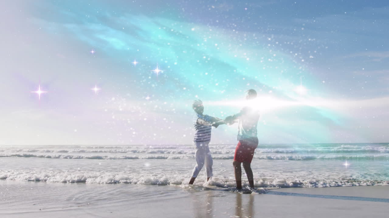 Couple enjoying beach with sparkling light animation over ocean waves
