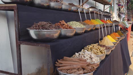 close up overview across lots of vibrant colourful herb - spice powders in outdoor store market scene