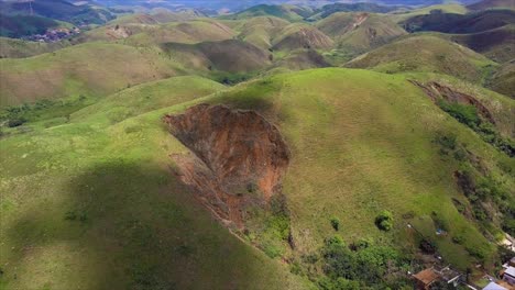 Flyover-above-large-eroded-area-of-hill-above-village