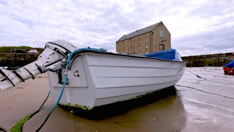 boat resting on sandy beach in fife