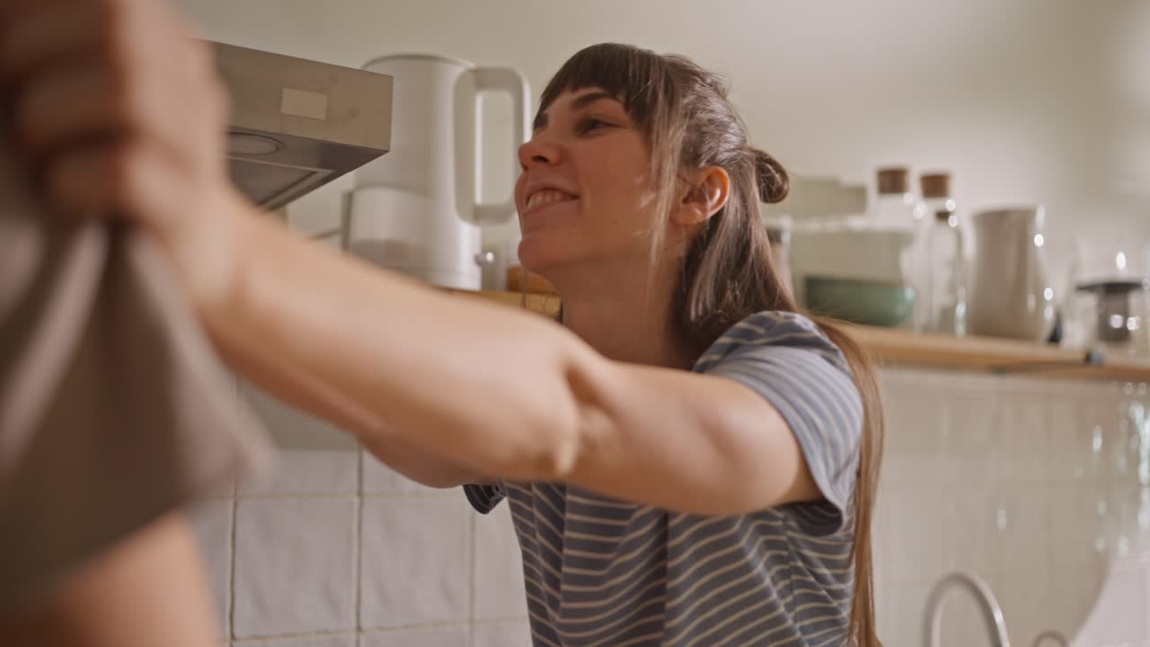 A woman is talking in a kitchen