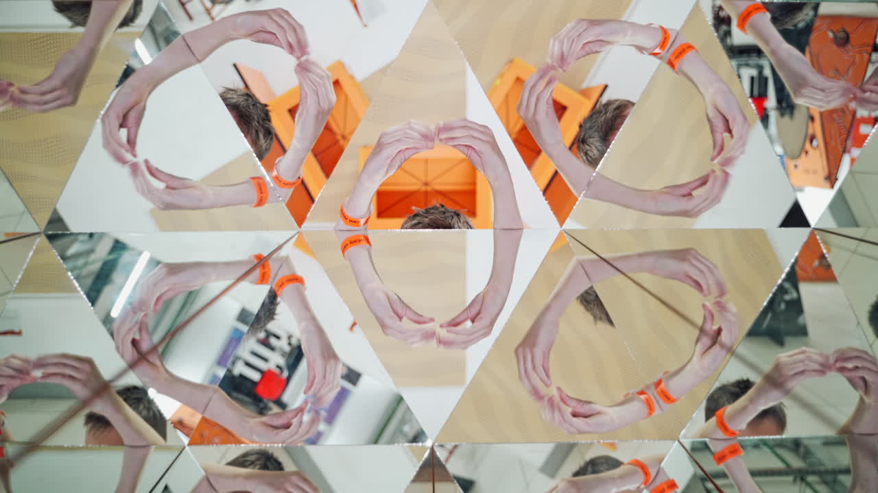 Boy's hands guestures in many parts of kaleidoscope reflection. Geometric design of a happy child playing on the background of mirror in kaleidoscope