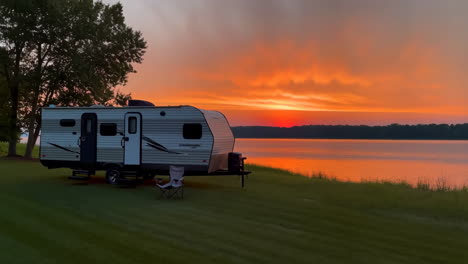 travel trailer by a lake at sunset
