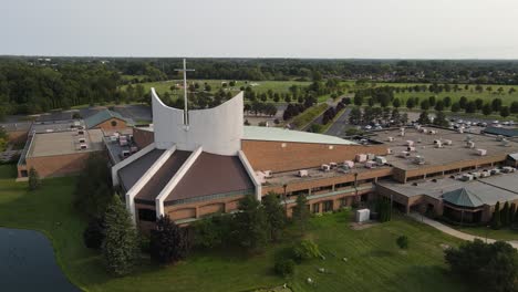 Bethesda-Christian-Church-exterior-with-tall-cross-on-top,-aerial-ascend-view