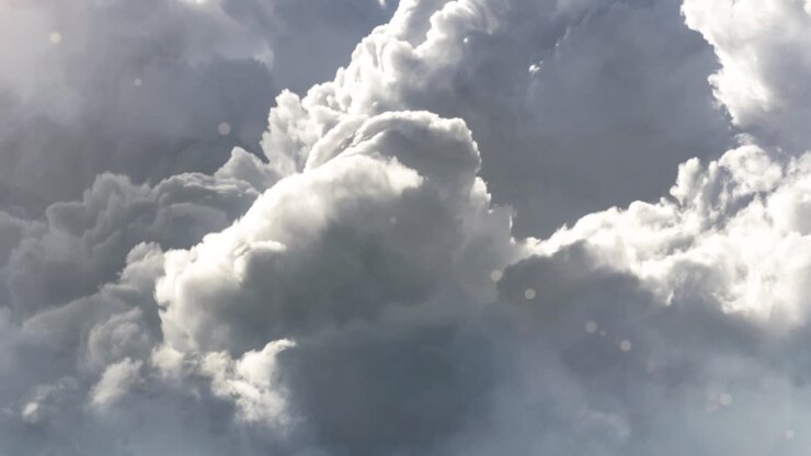 cumulus clouds, dark gray with sunlight moving across the sky