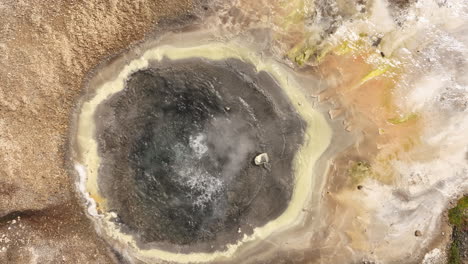 geothermal field boiling water in a natural basin aerial top shot slow motion