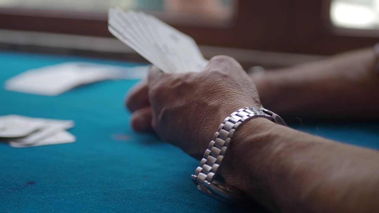 Hand holding playing cards on a poker table