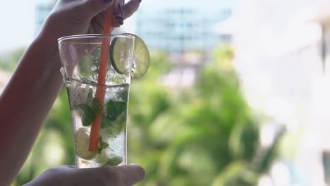 Mädchen-Rührt-Gefrorenen-Mojito-Mit-Plastikstrohhalm-In-Einem-Hohen-Glas