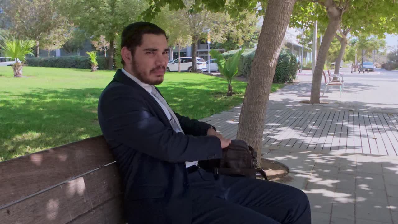 Professional Man Organizing His Briefcase on a Park Bench