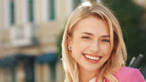 счастливая женщина в розовом блейзере.