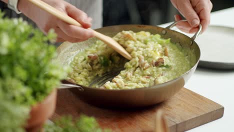 chef mixing risotto in pan