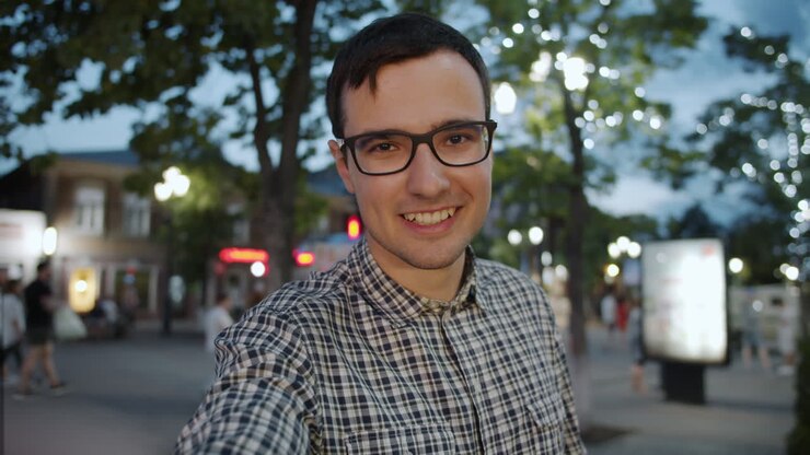 Uomo che si scatta un selfie in una strada cittadina di notte
