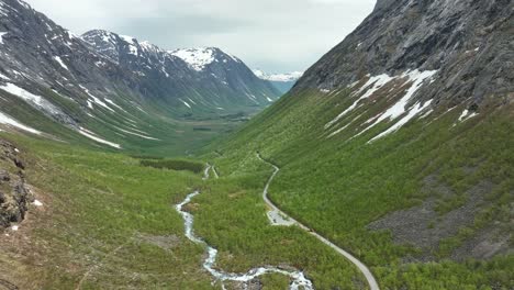 Stunning-lush-green-Isterdalen-valley-between-Trollstigen-road-ans-Andalsnes-city-in-Rauma-Norway---Aerial