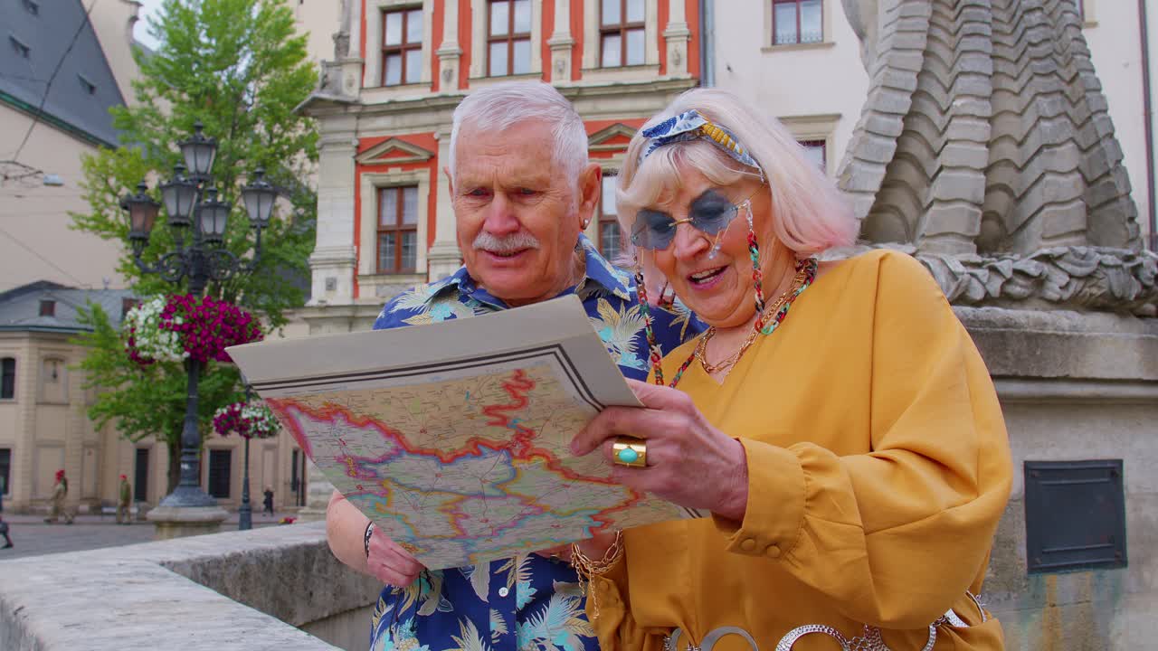 Senior grandmother and grandfather tourists looking for a place to go in new city using paper map