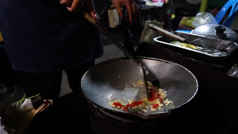 chilli and garlic being stir-fried in a wok