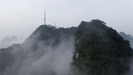 yangshuo mountains 4k drone pull back from tv tower above the misty clouds