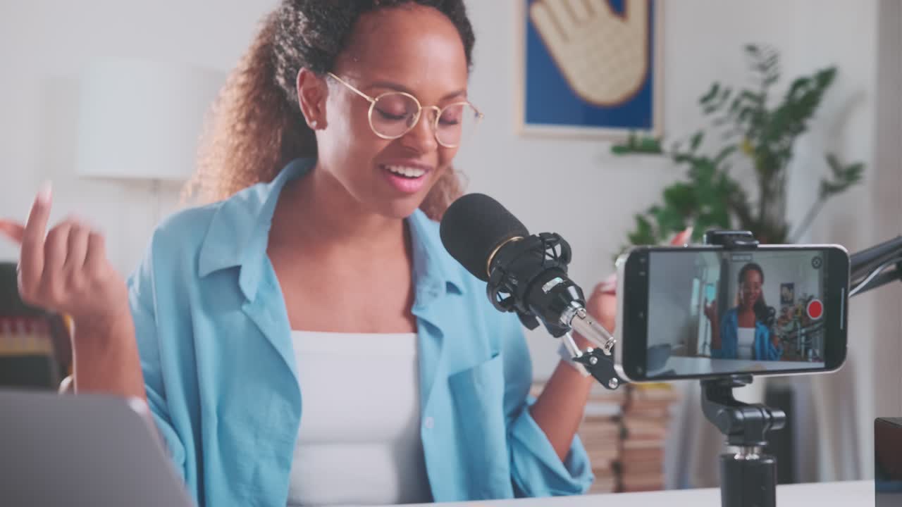 joven feliz mujer afroamericana blogger anfitriona de video podcast se sienta en la mesa