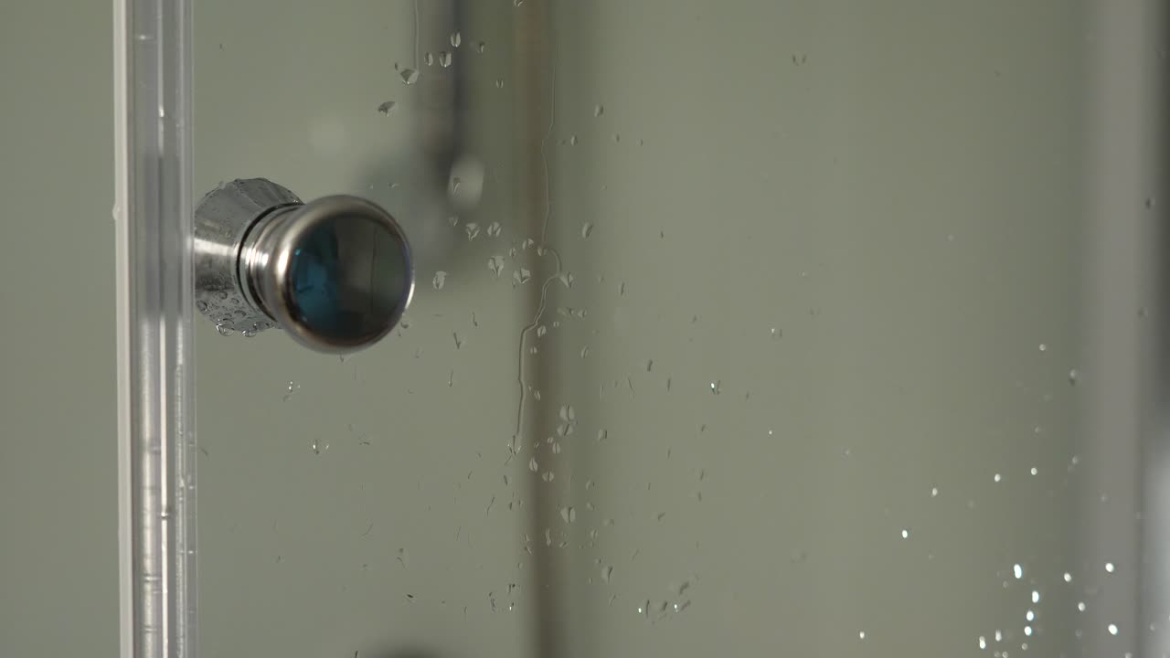 persona abriendo una puerta de la ducha