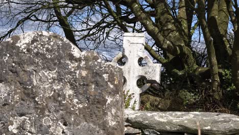 viejo cementerio de la hambruna irlandesa cruz celta detrás de la antigua lápida en la primavera