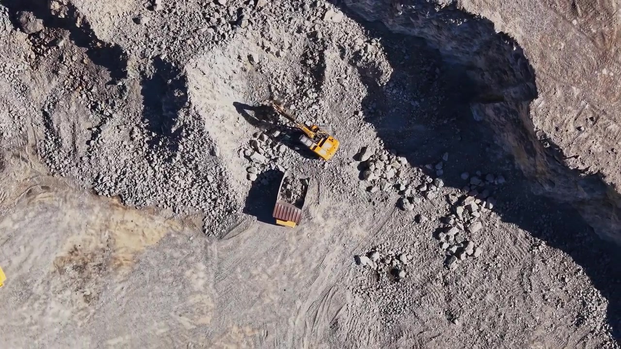 Excavator working in a quarry during daytime hours