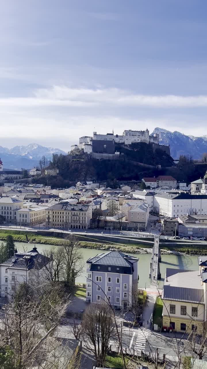 View overlooking Salzburg Fortress perched above Salzburg city with snow-brushed mountains in the background