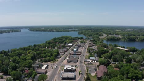 Aerial-wide-panning-shot-of-downtown-Lindstrom,-Minnesota-surrounded-by-lakes