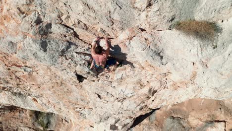 man rock climbing on a cliff - aerial view