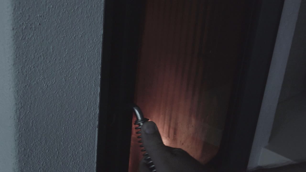 4K slider footage of man putting wooden logs in wood-burning stove while fire is still burning