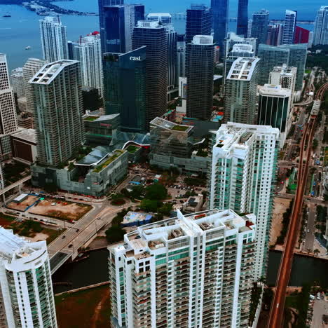 approaching the tops of high-rise blocks of flats in the modern city downtown. scenic view of miami, florida, usa on grey daytime.