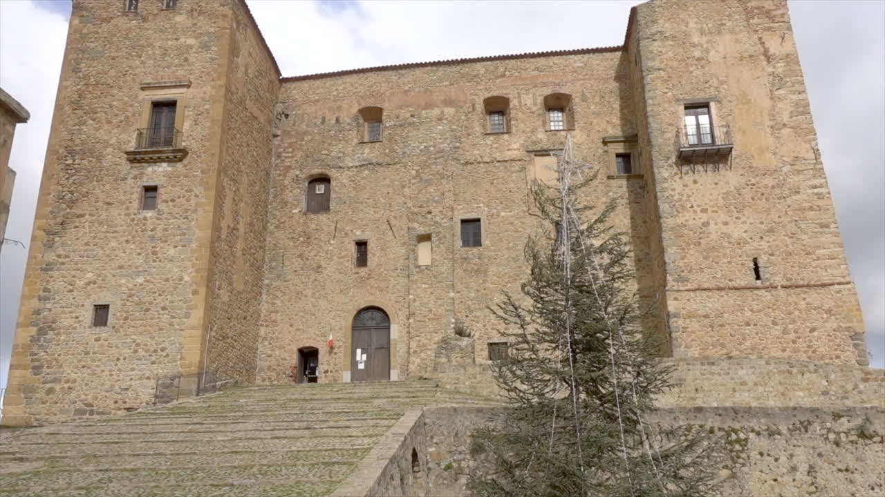 View of the charming town of Castelbuono, Sicily, renowned for its medieval castle and the famous Fiasconaro panettone in the heart of Sicily. Long shot over the square on a winter day