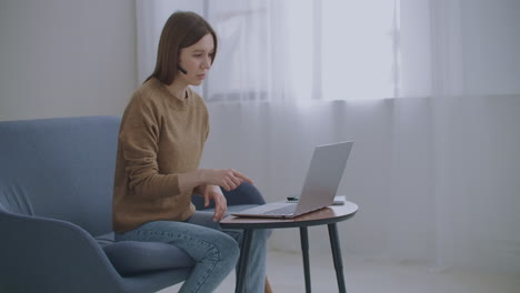 La-Mujer-Se-Comunica-En-Línea-Usando-Una-Computadora-Portátil-Con-Internet-Y-Auriculares-Con-Micrófono,-Soporte-Técnico-De-Chat-En-Línea