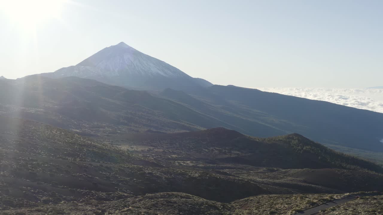 Awe Inpiring mountain view, Teide in Tenerife with sunflare and rolling clouds. Drone panning right.