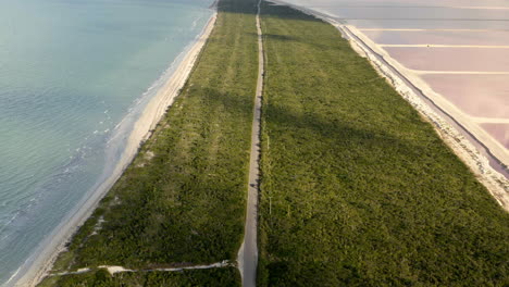 Car-driving-on-long-road-on-isthmus-between-sea-and-salt-ponds,-Mexico