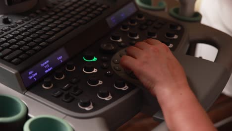 person adjusting ultrasound machine controls