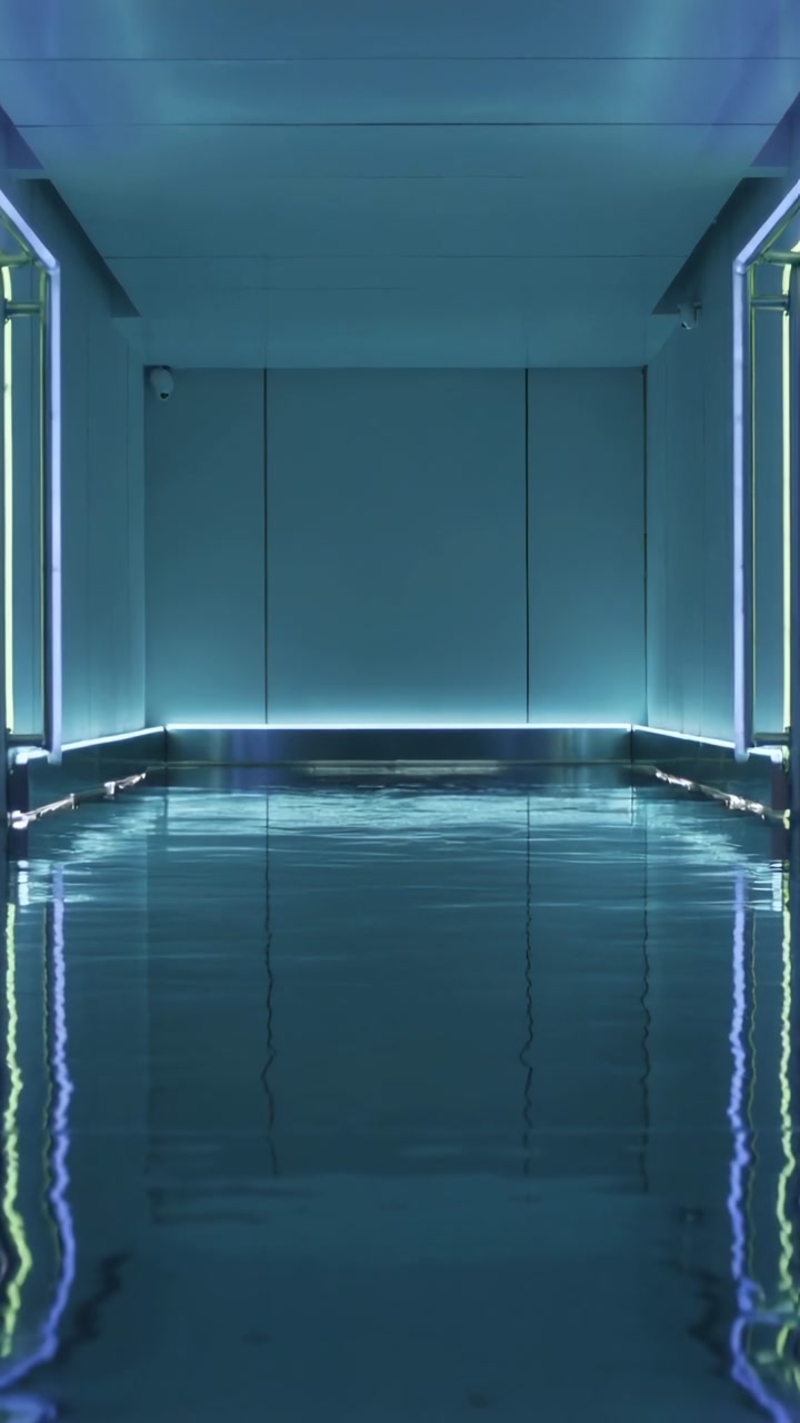 Vertical video: Starting ripples on wet floor shifting lights along sci-fi corridor with LEDs