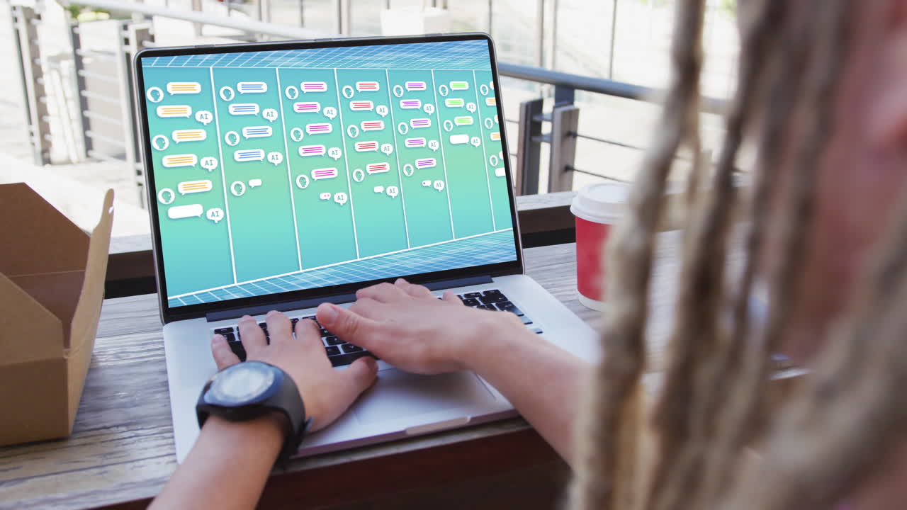 un hombre de negocios biracial usando una computadora portátil con notificaciones de mensajes en la pantalla de la oficina.