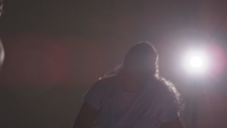 Backlit-Studio-Shot-Of-Young-Woman-Dancer-Being-Filmed-Dancing-In-Front-Of-Spotlight