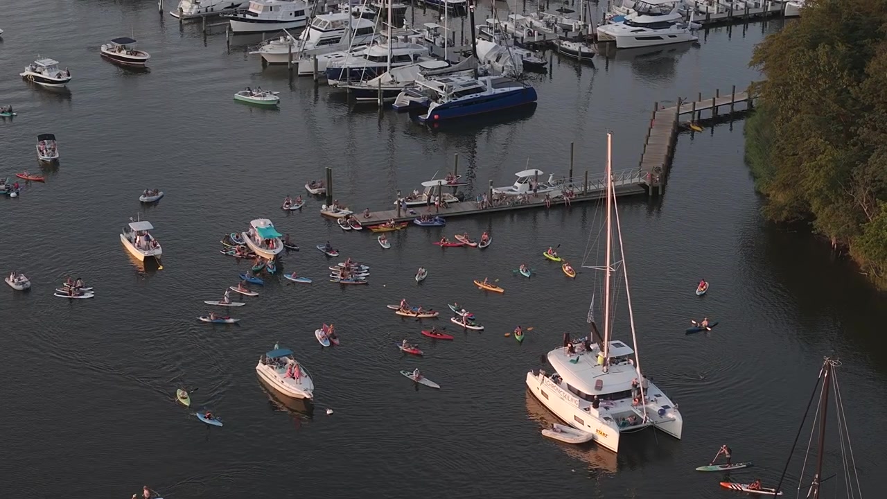 Persone che si radunano su barche e kayak per l'evento comunitario settimanale "Tunesday" su Back Creek ad Annapolis, Maryland. - ripresa aerea
