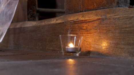 candlestick with a lit candle serving as a decoration in an old church