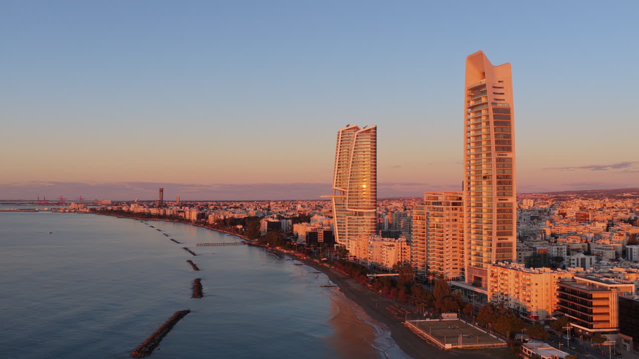 Vista aerea con drone di moderni grattacieli lungo la costa di Limassol al tramonto.