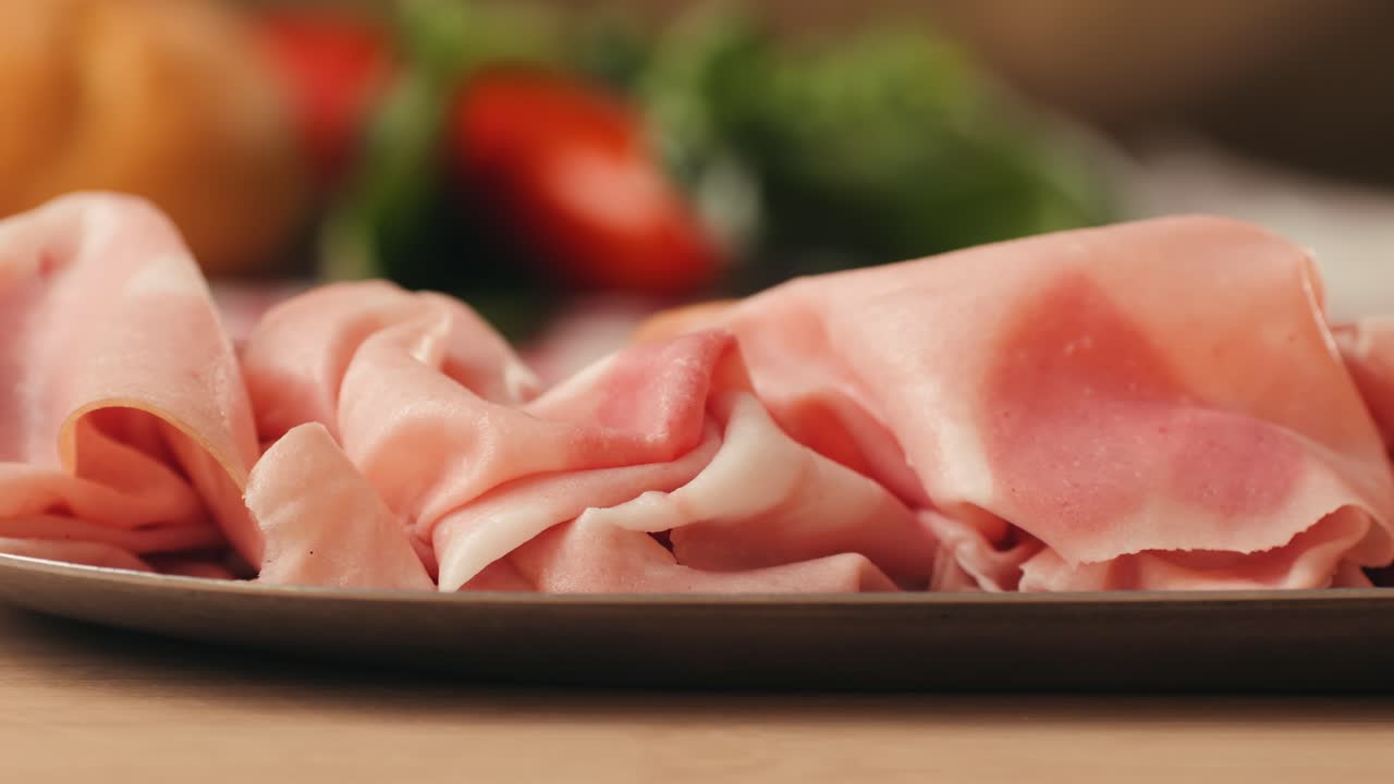 Ham italian mordatella, man Slices Of Traditional Italian antipasti mortadella sausage on a wooden cutting board, close up macro of chicken or turkey jamon, fat breakfast dish.