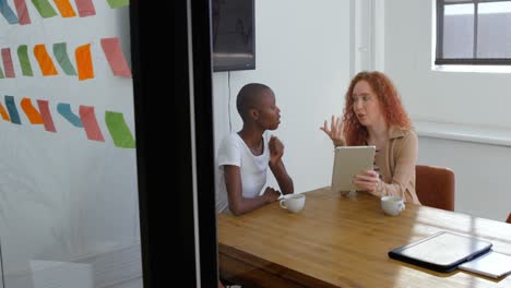 Front-view-of-young-mixed-race-business-team-working-on-digital-tablet-in-a-modern-office-4k