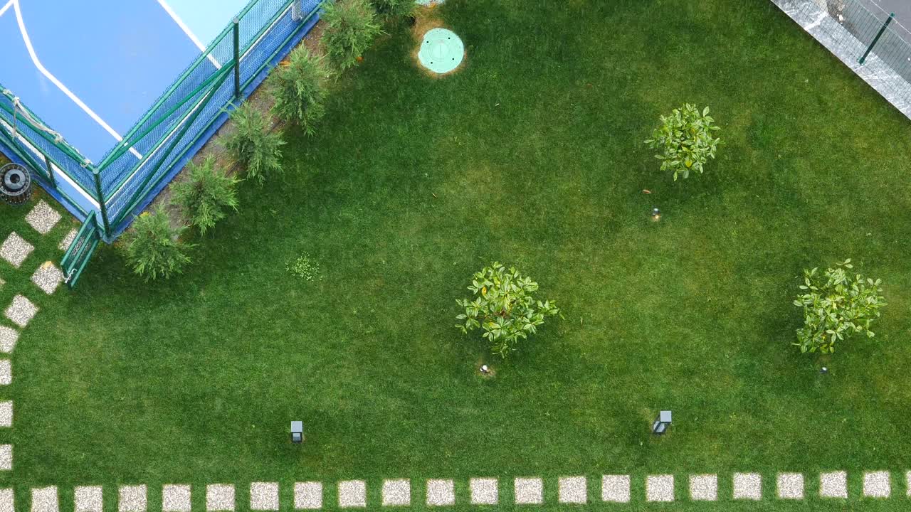 Aerial View of a Green Lawn with a Basketball Court