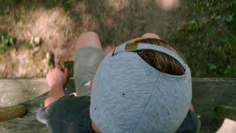 Manchild-swinging-in-the-woods-pov-top-shot