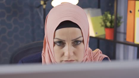 Eine-Geschäftsfrau-Im-Hijab,-Die-Sich-Im-Büro-Auf-Den-Computer-Konzentriert,-Erledigt-Eine-Wichtige-Arbeit.