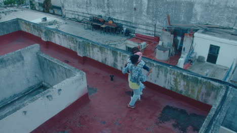 couple dancing tango on a rooftop in poor district