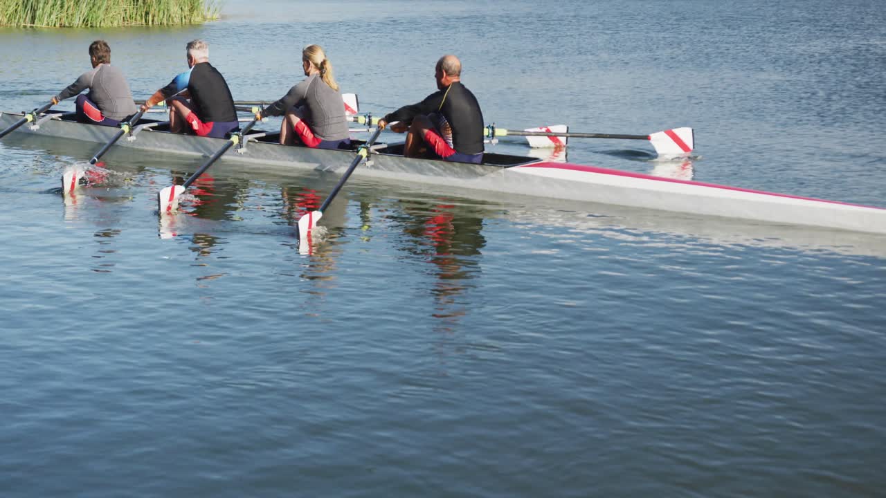Four senior caucasian men and women rowing boat on a river