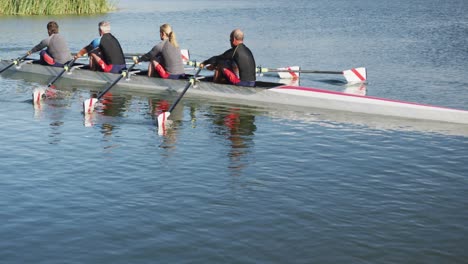 Four-senior-caucasian-men-and-women-rowing-boat-on-a-river