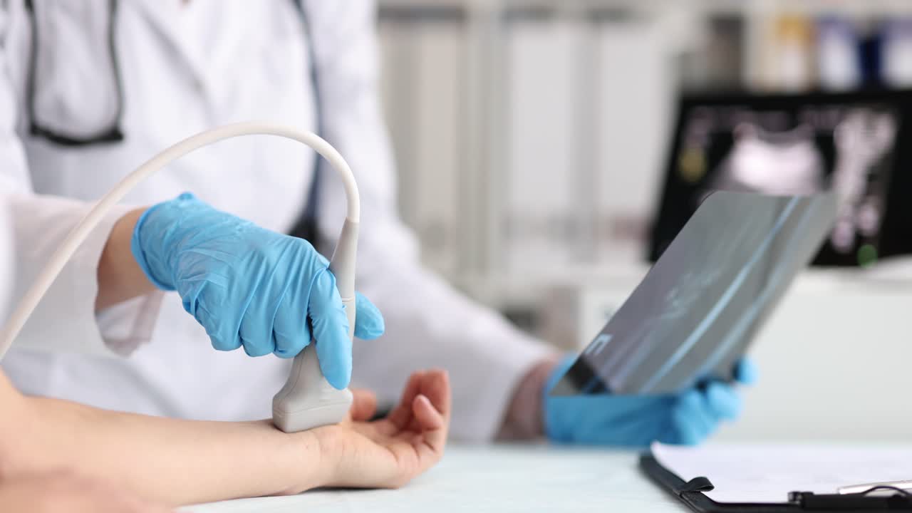 Doctora realiza ecografía de la muñeca de una mujer en la clínica.