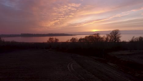 lake burtnieks in late autumn red sky sunset aerial wide view wit tree silhouette